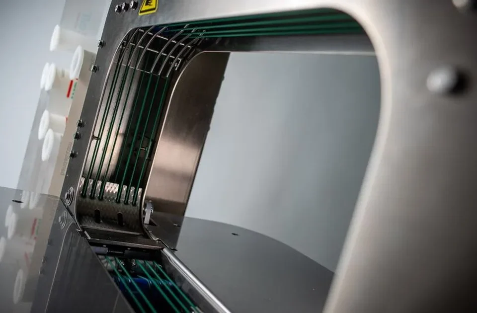 Banding machine uptime — the green belts inside the arch