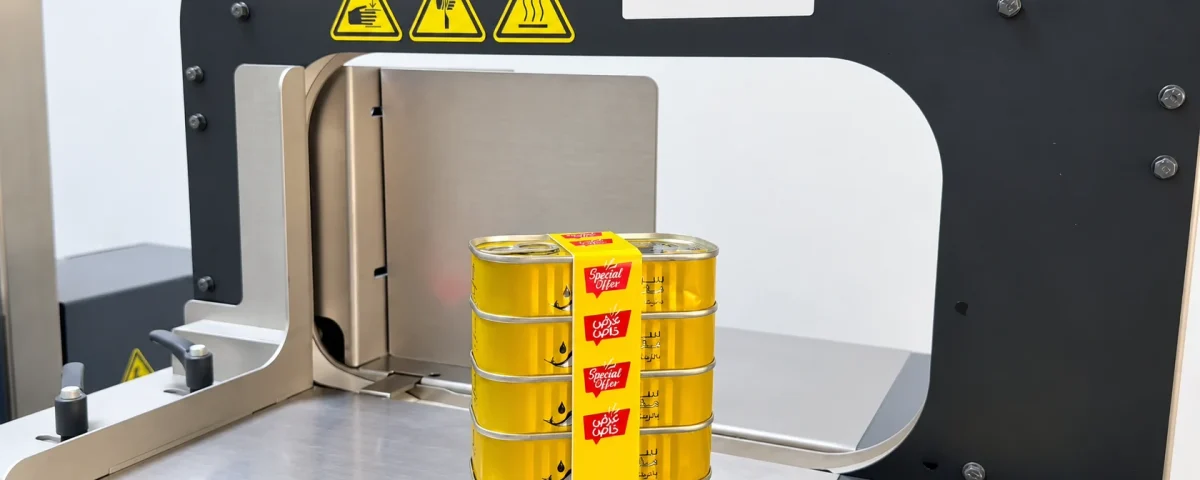 A stack of five yellow cans with a printed Special Offer band on a Bandall banding machine